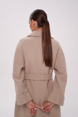 Woman wearing a beige coat on a white background