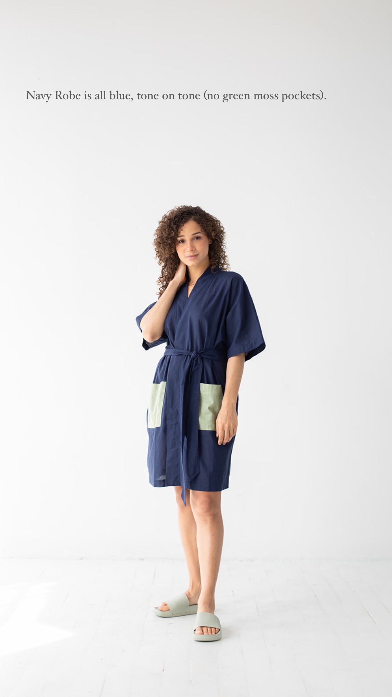 Woman wearing a navy robe with white text on a white background