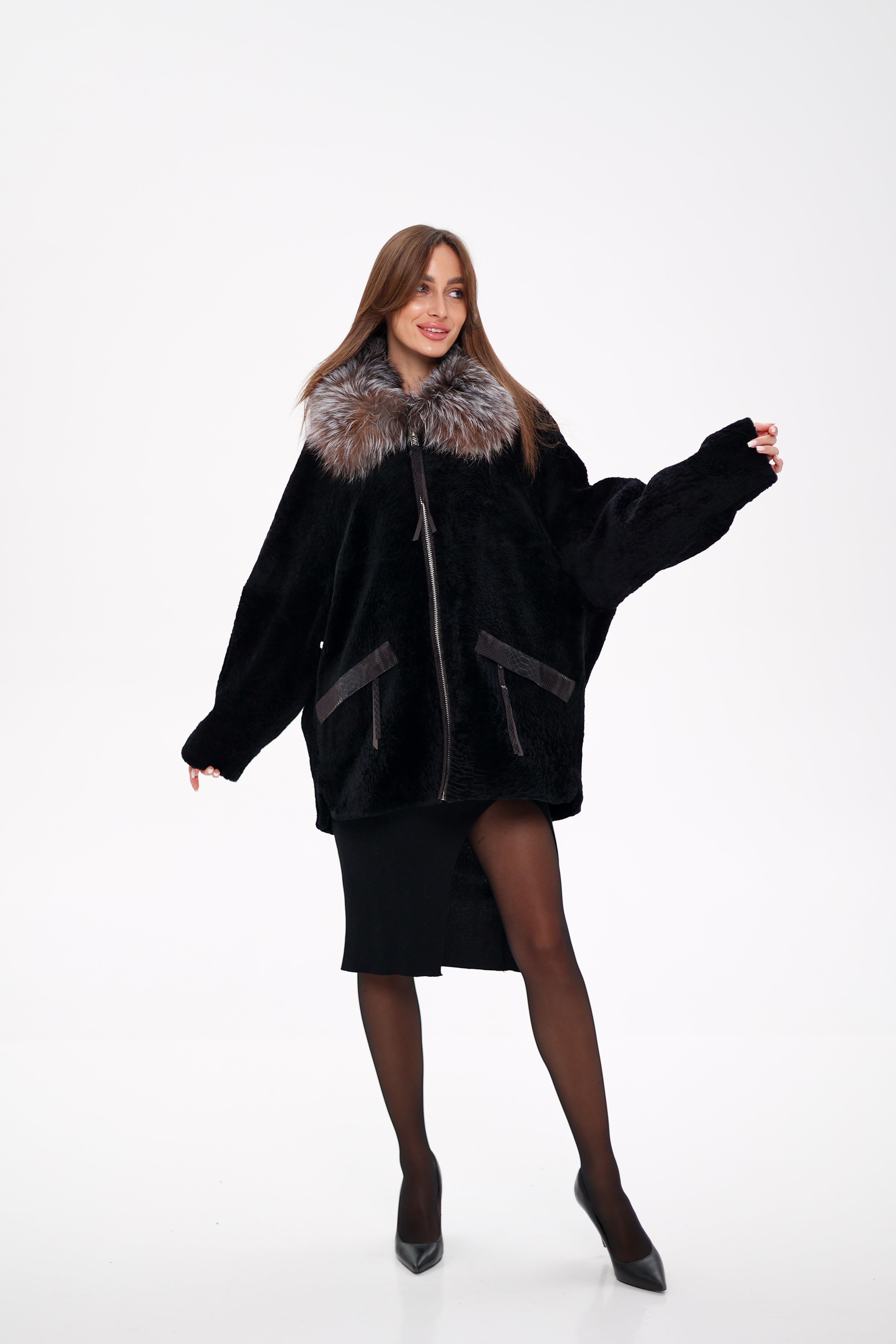 Woman wearing a black coat with fur trim on a white background