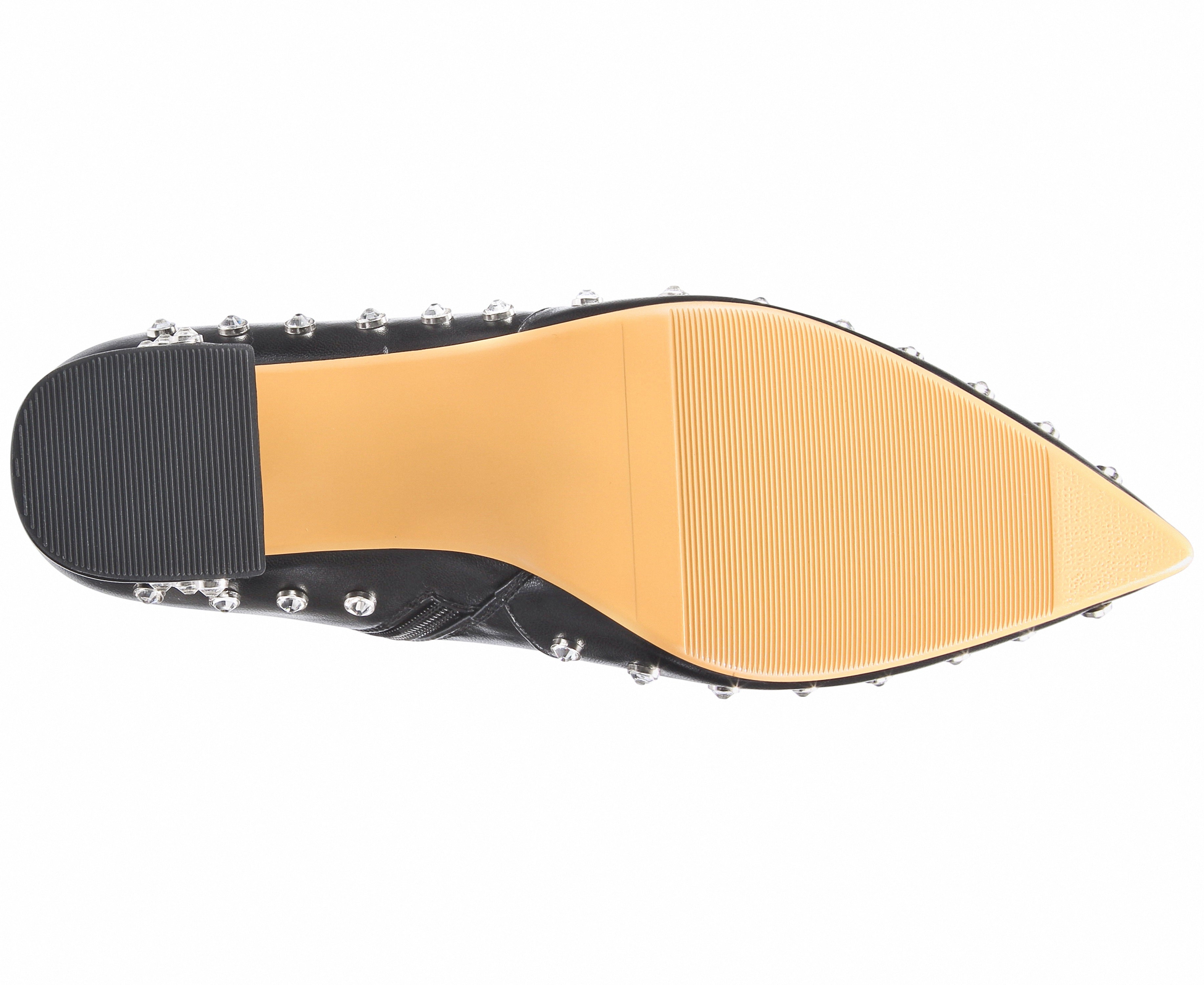 Close-up of a shoe sole with a black insole and tan outsole on a white background