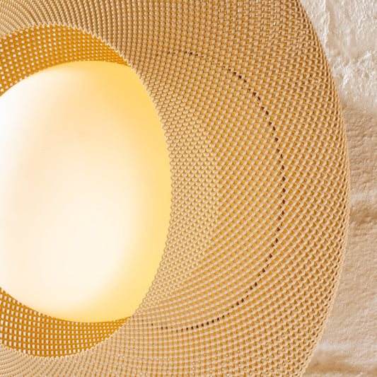 Round woven placemat with a glowing light bulb inside on a textured beige background