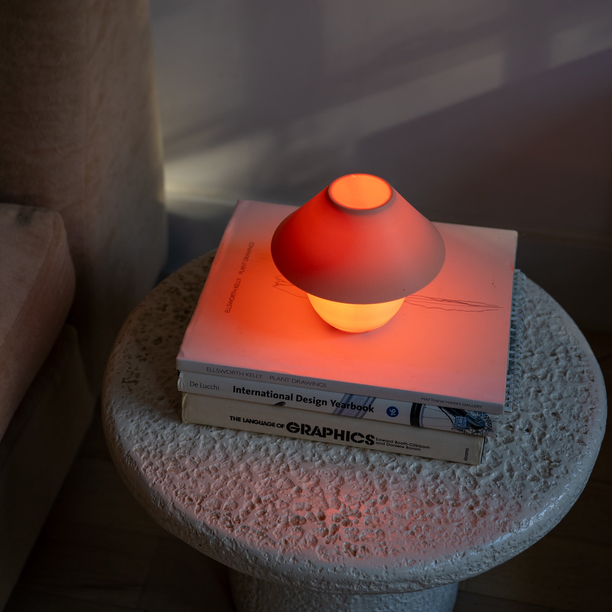 Small lamp on a stack of books on a textured surface with a blurred background