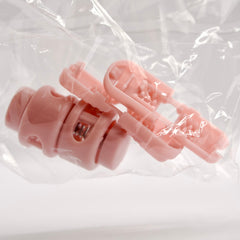 Pink hair clip in clear plastic packaging on a white background