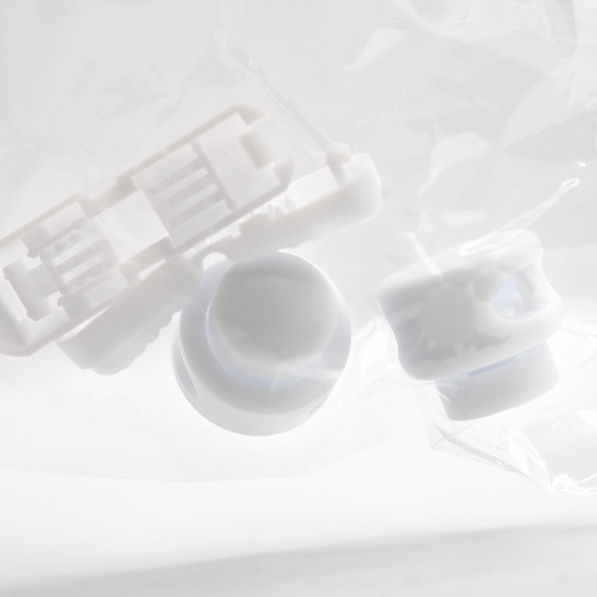 White plastic components on a light gray background