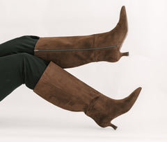 Brown suede knee-high boots on a white background