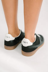 Black and white sneakers with 'UMIA' branding on a light background