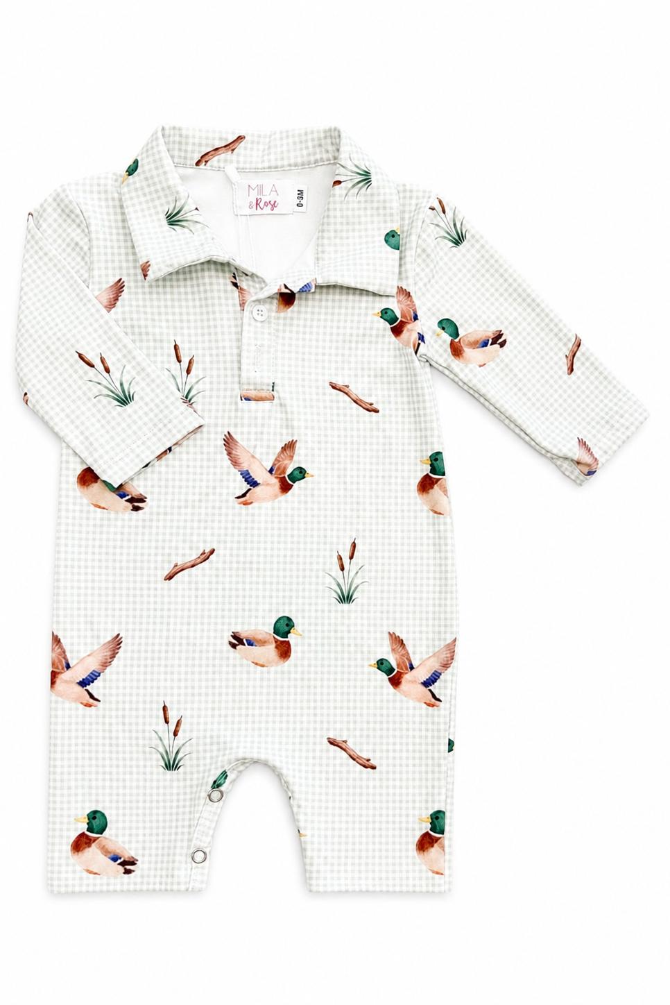 A long-sleeve baby romper in a white and light green gingham pattern, featuring a watercolor print of mallards and reeds, laid flat on a white background.