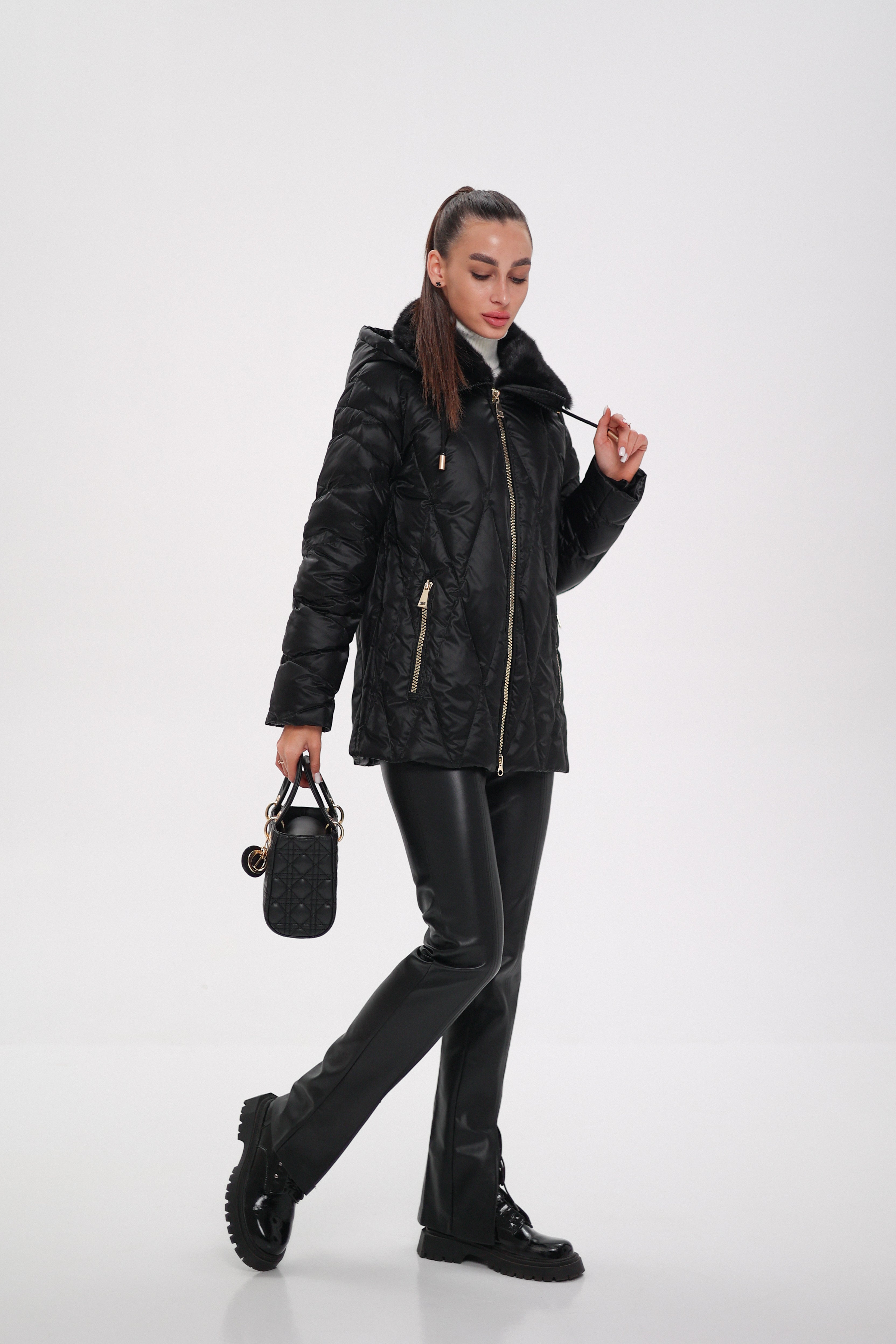 Woman wearing a black leather jacket and pants on a white background