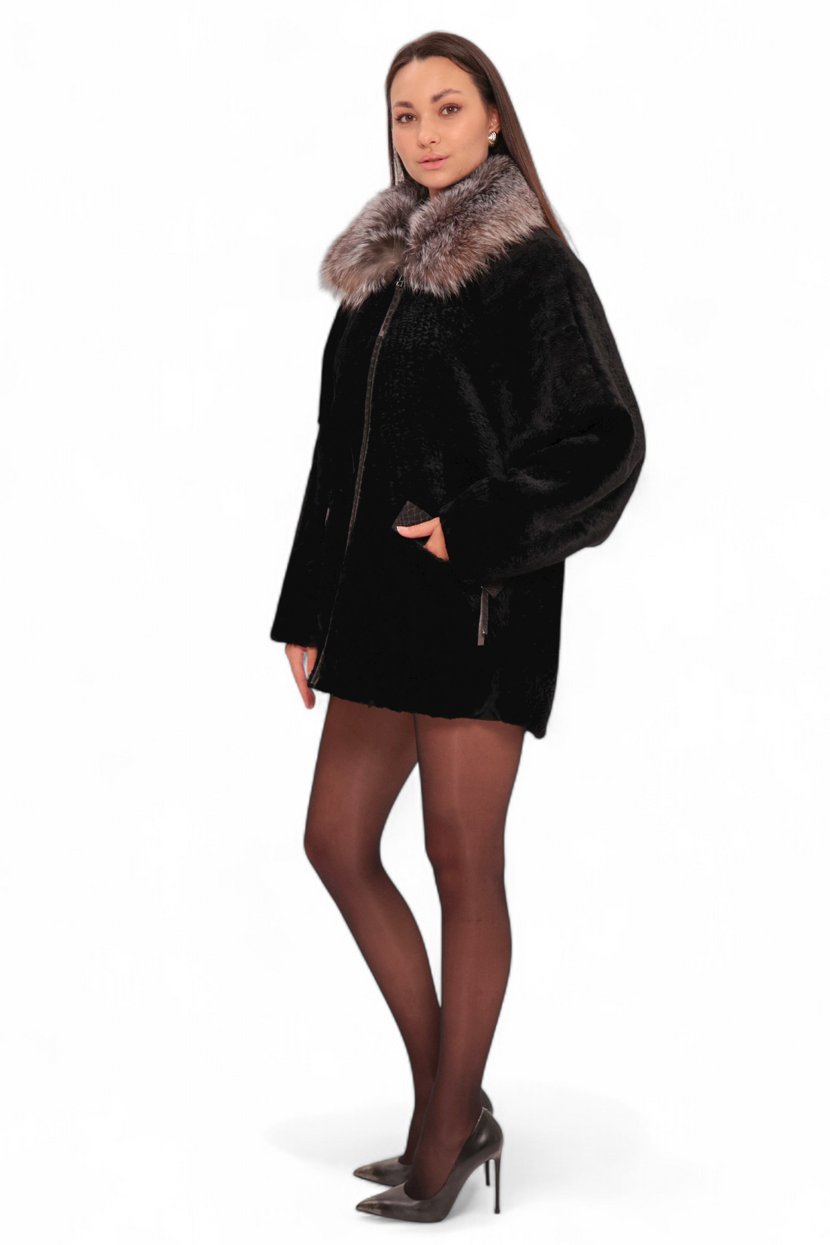 Woman wearing a black coat with fur collar on a white background