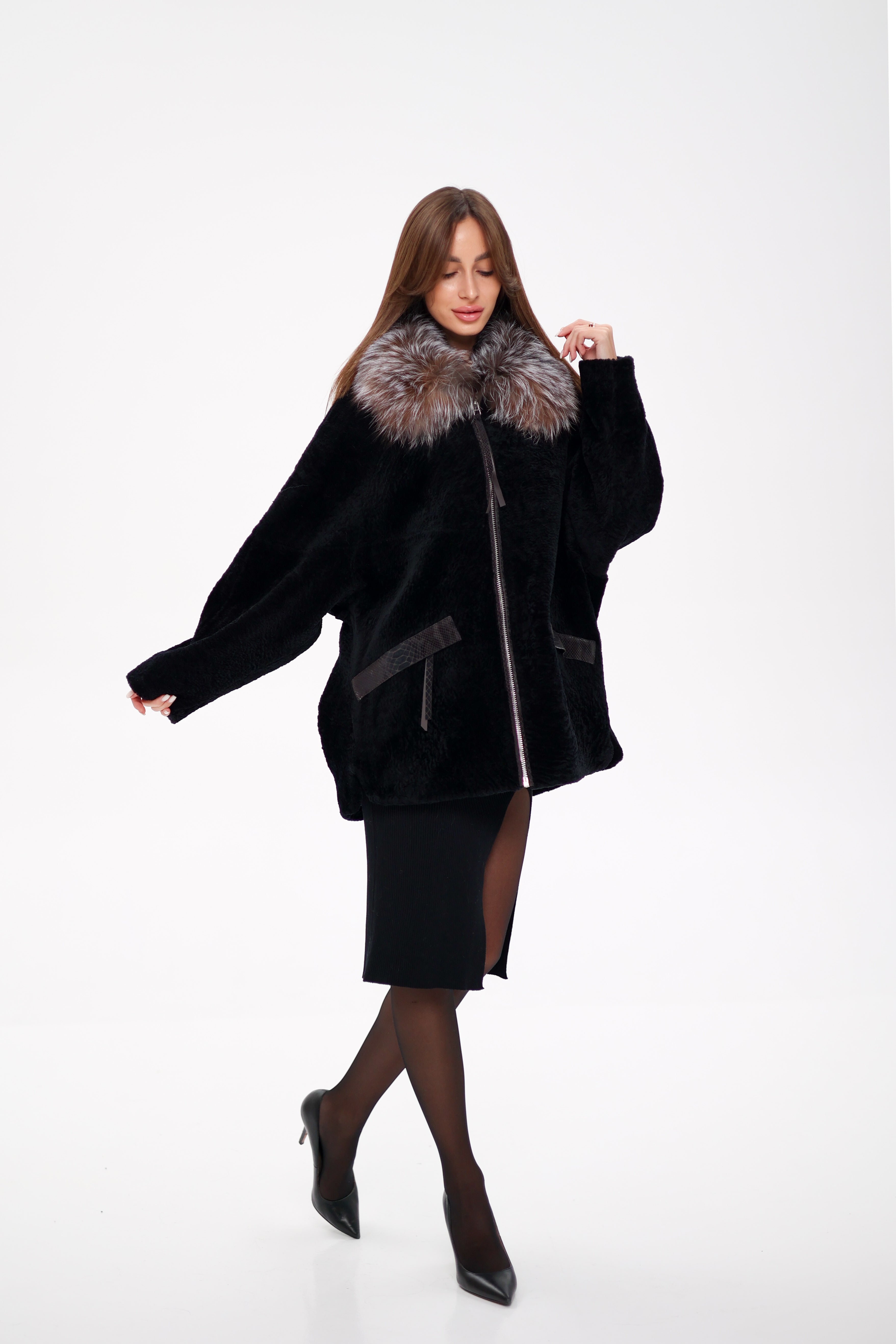 Woman wearing a black coat with fur collar on a white background