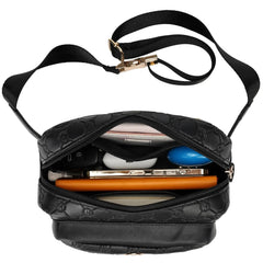 Black quilted handbag with a strap, containing a smartphone and other items on a white background