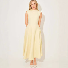 Woman wearing a light yellow dress against a white background
