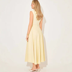 Woman wearing a light yellow dress with cut-out sides on a white background
