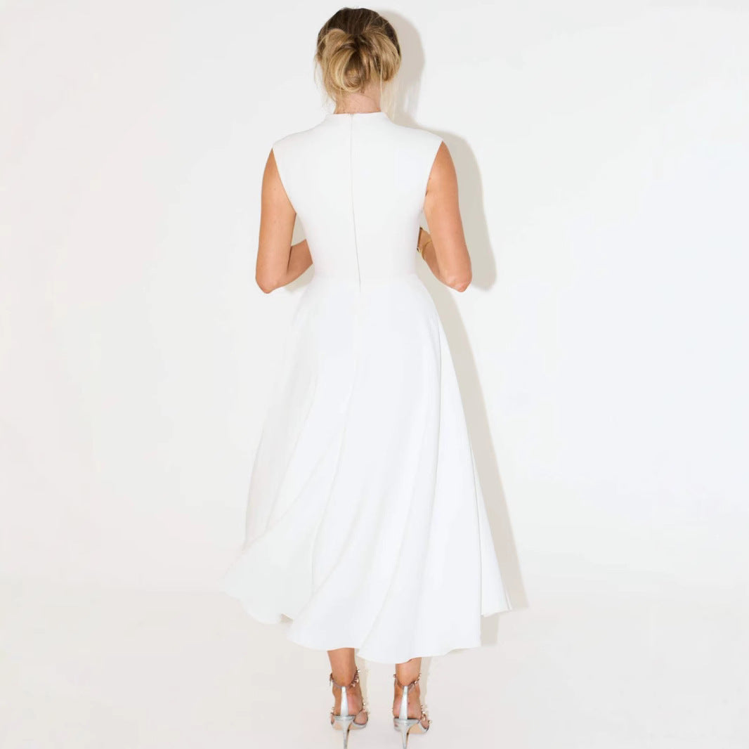 Woman wearing a white sleeveless dress against a plain background