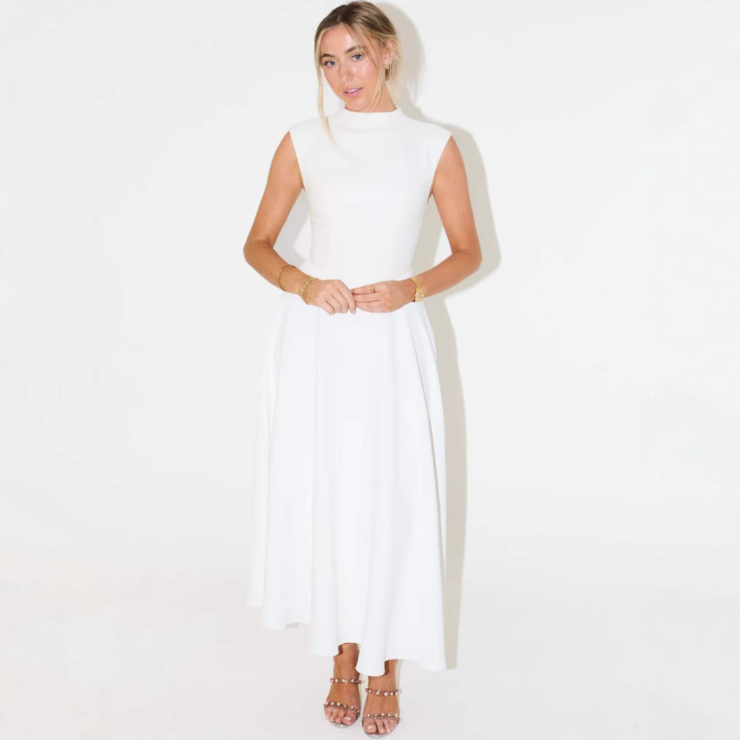 Woman wearing a white sleeveless dress against a plain background
