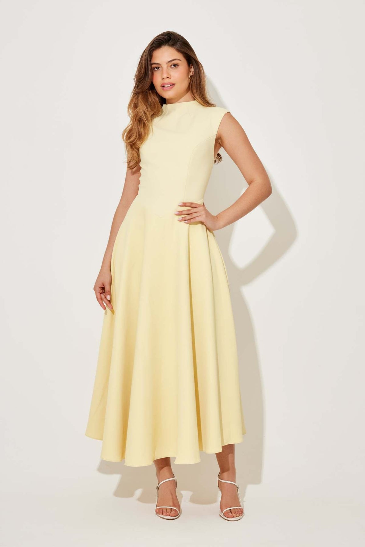 Woman wearing a light yellow dress against a white background