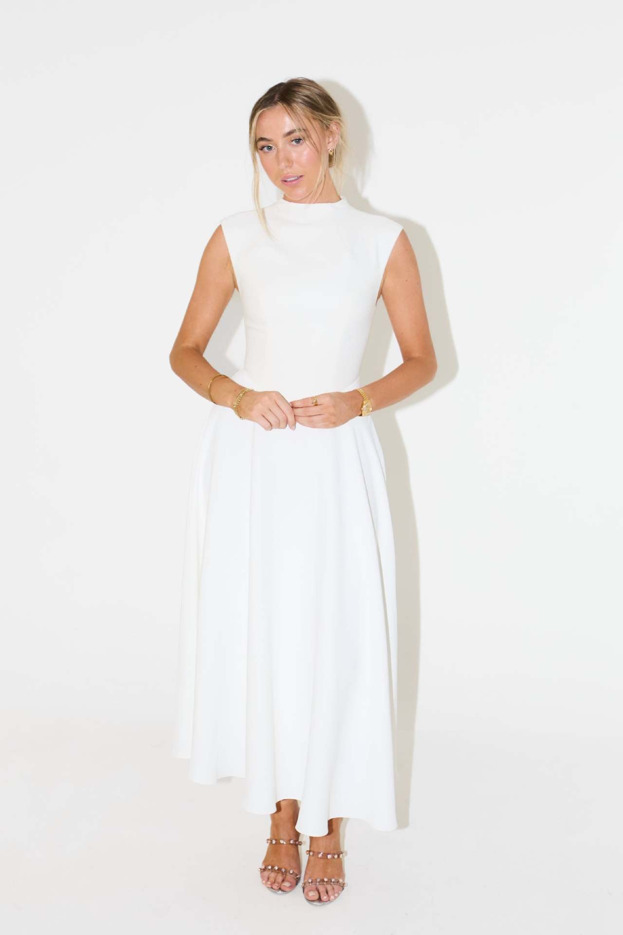 Woman wearing a white sleeveless dress on a white background