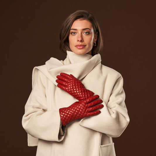 Woman wearing a white coat and red gloves against a brown background