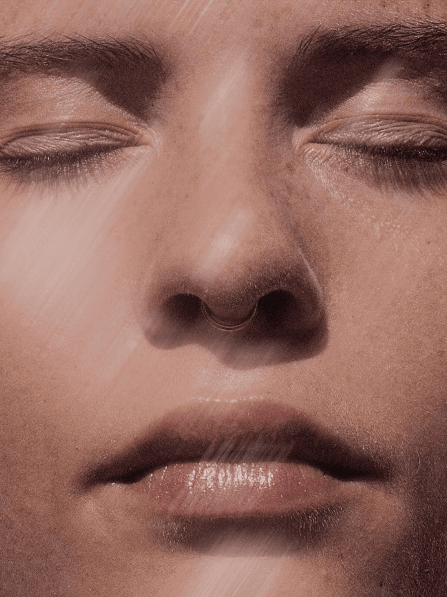 Close-up of a person's face with closed eyes and a neutral expression.