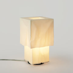 Square table lamp with a beige fabric shade on a light gray background