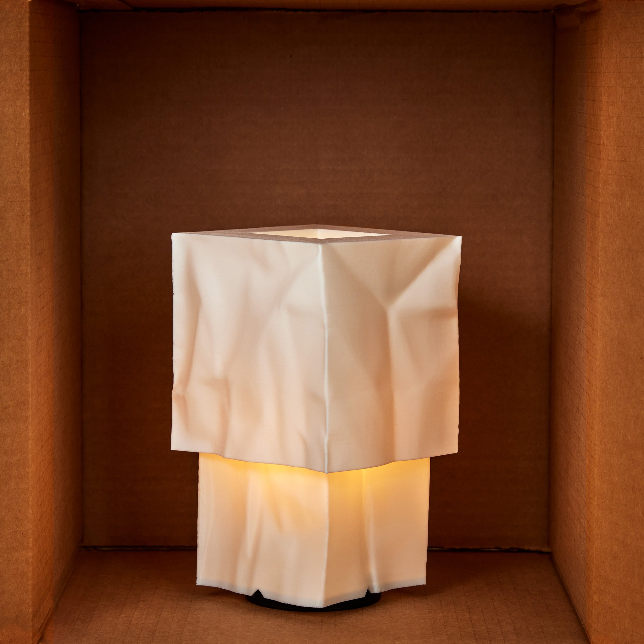 Square lamp with a textured white shade in a brown box