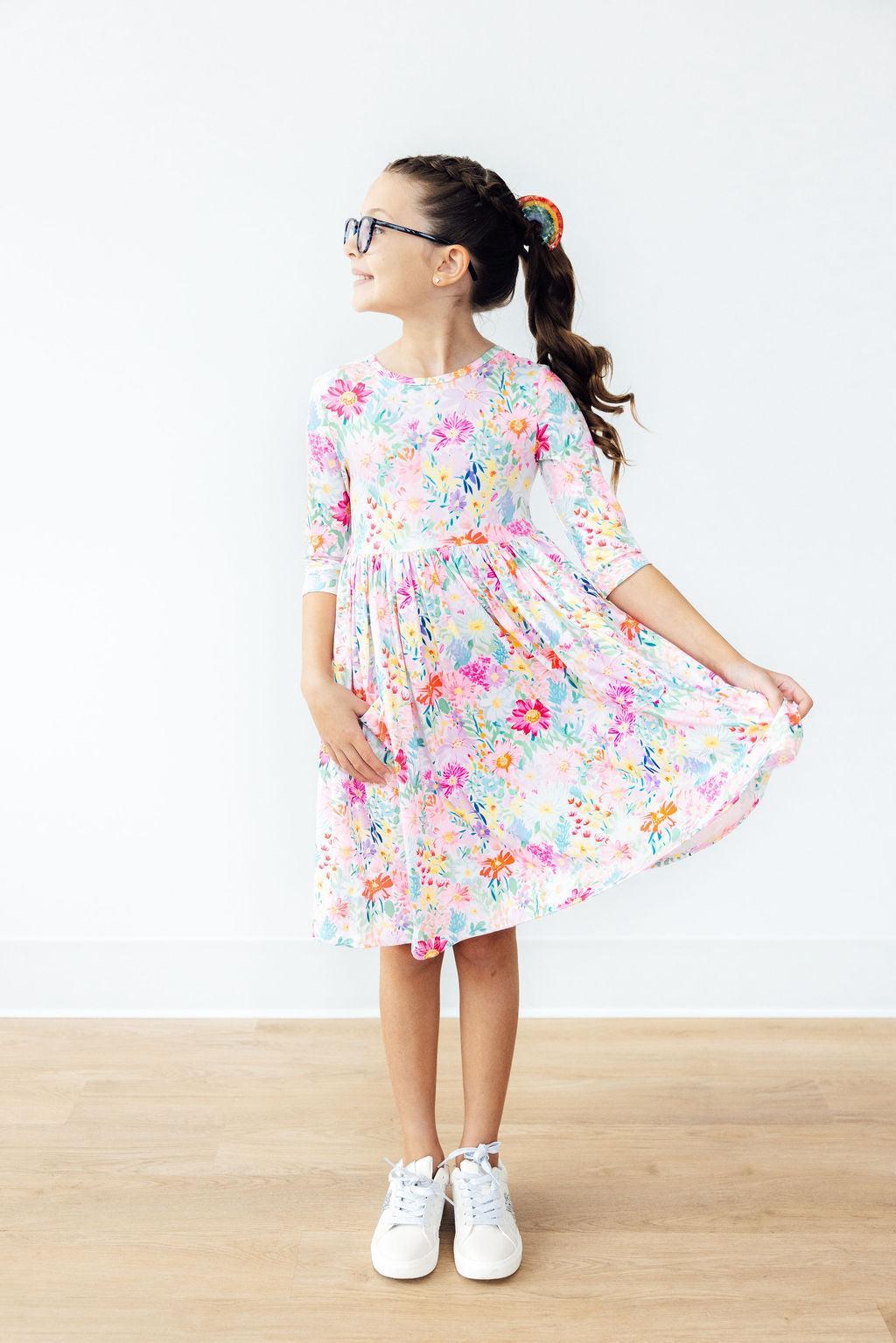 Young girl wearing a floral dress on a white background