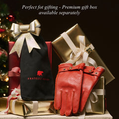 Red leather gloves with a black gift bag featuring a brand logo, set against a festive background.