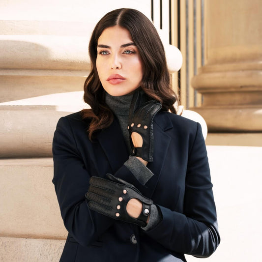 Woman wearing a dark coat and gloves in an elegant interior setting