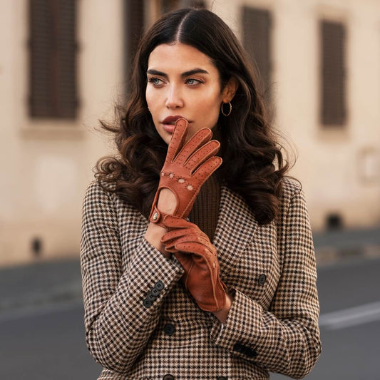 Woman wearing a checkered coat and brown leather gloves in an urban setting