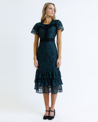 Woman wearing a dark green lace dress on a white background