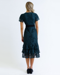 Woman wearing a dark blue lace dress on a white background