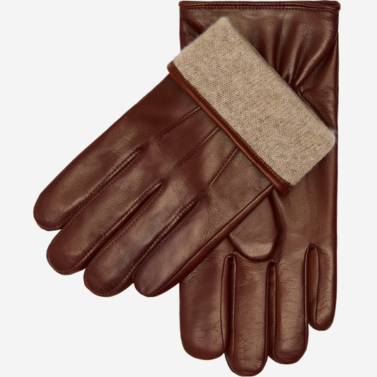 Pair of brown leather gloves with beige lining on a white background