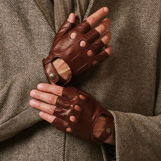 Brown leather gloves worn by a person against a textured brown background