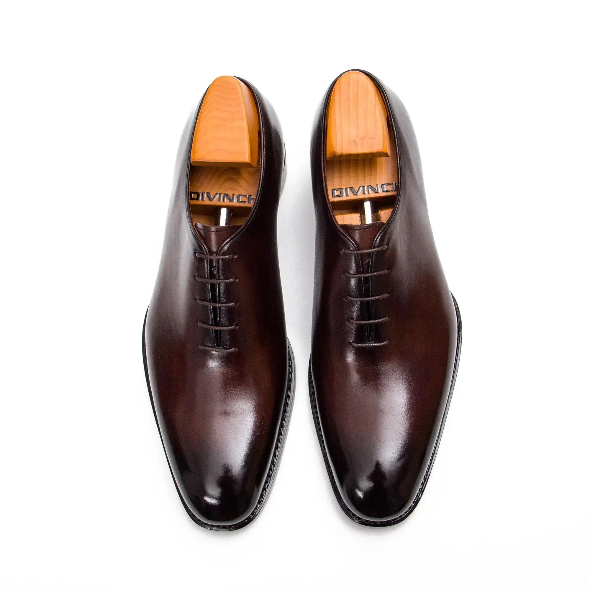 Pair of brown dress shoes with wooden soles on a white background