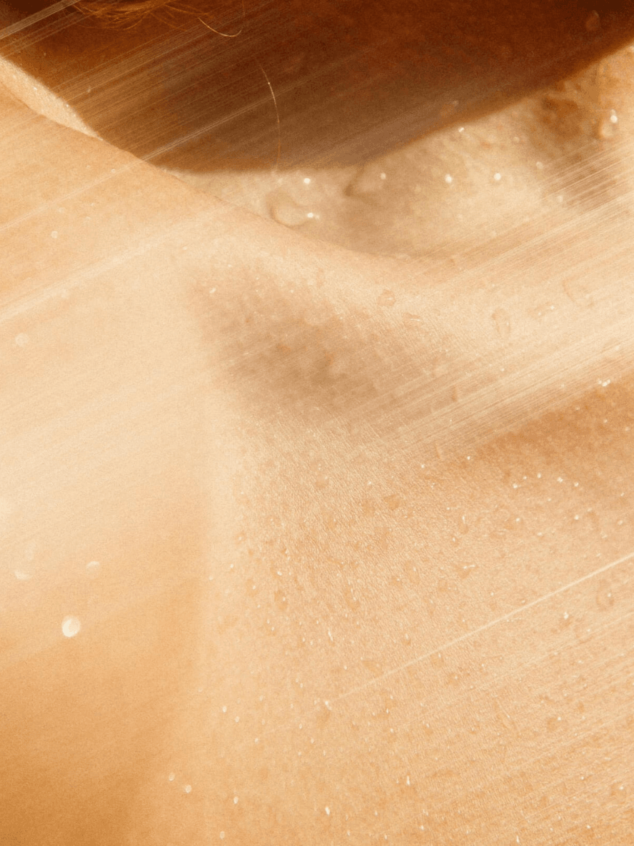 Close-up of a beige surface with a brush applying a substance