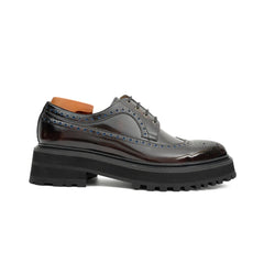 Black leather brogue shoe with a thick sole on a white background