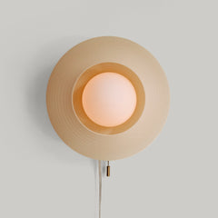 Wall-mounted lamp with a textured beige shade on a light gray background