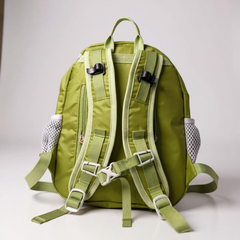 Green backpack with multiple straps on a light gray background