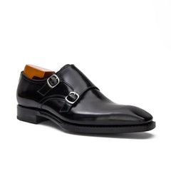 Black leather dress shoe with double buckle on a white background