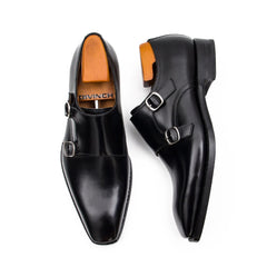 Black leather shoes with brown soles on a white background
