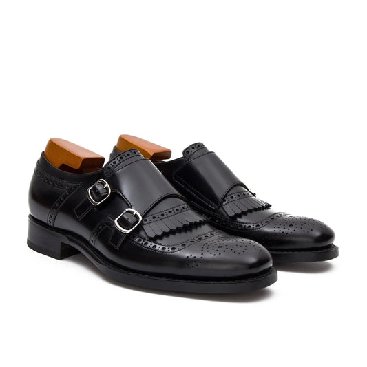 Black leather shoes with buckles on a white background