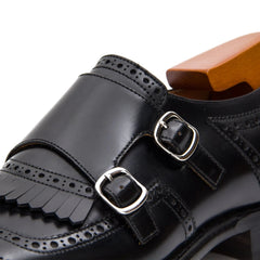 Black leather shoe with double buckles on a white background