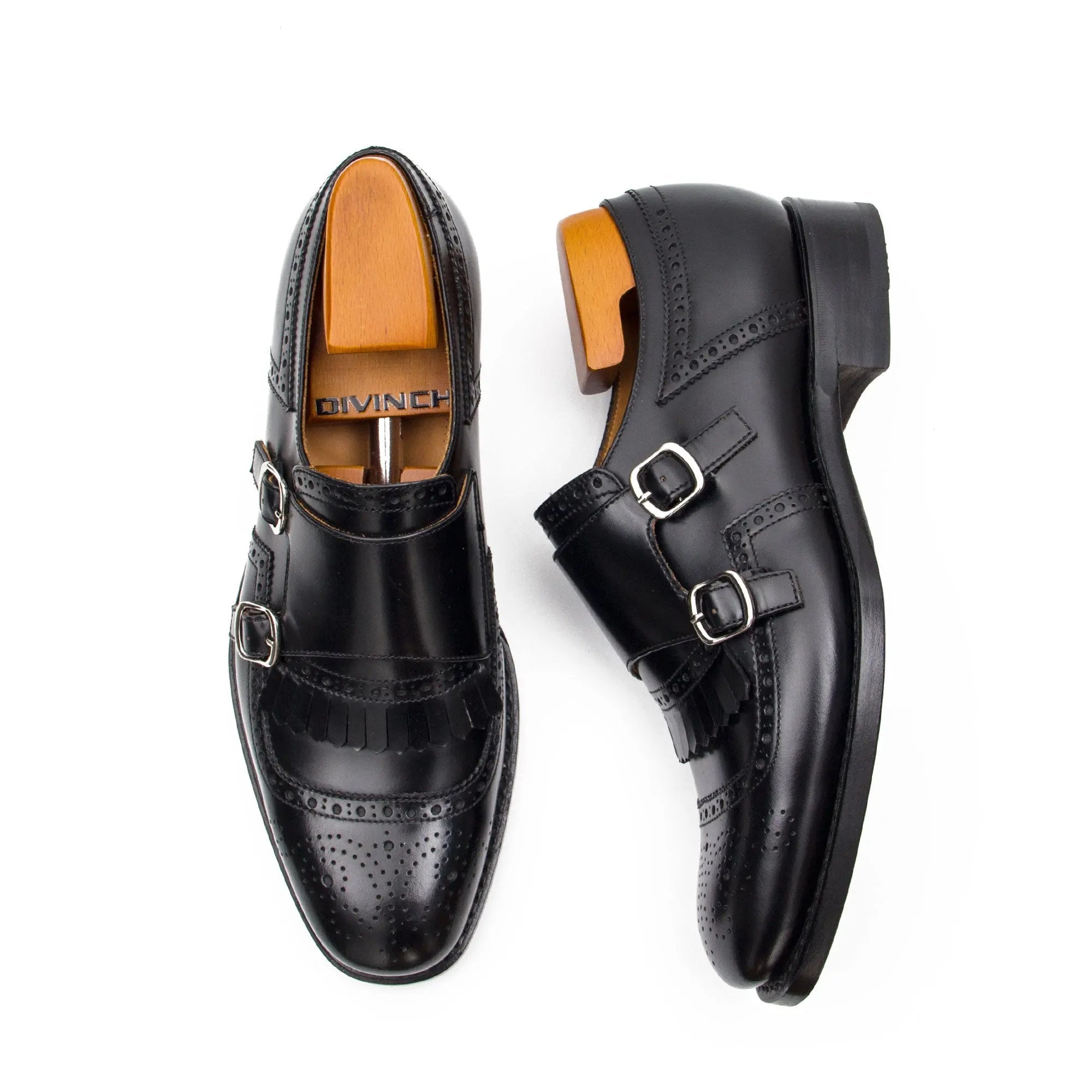 Pair of black leather dress shoes with brown soles on a white background