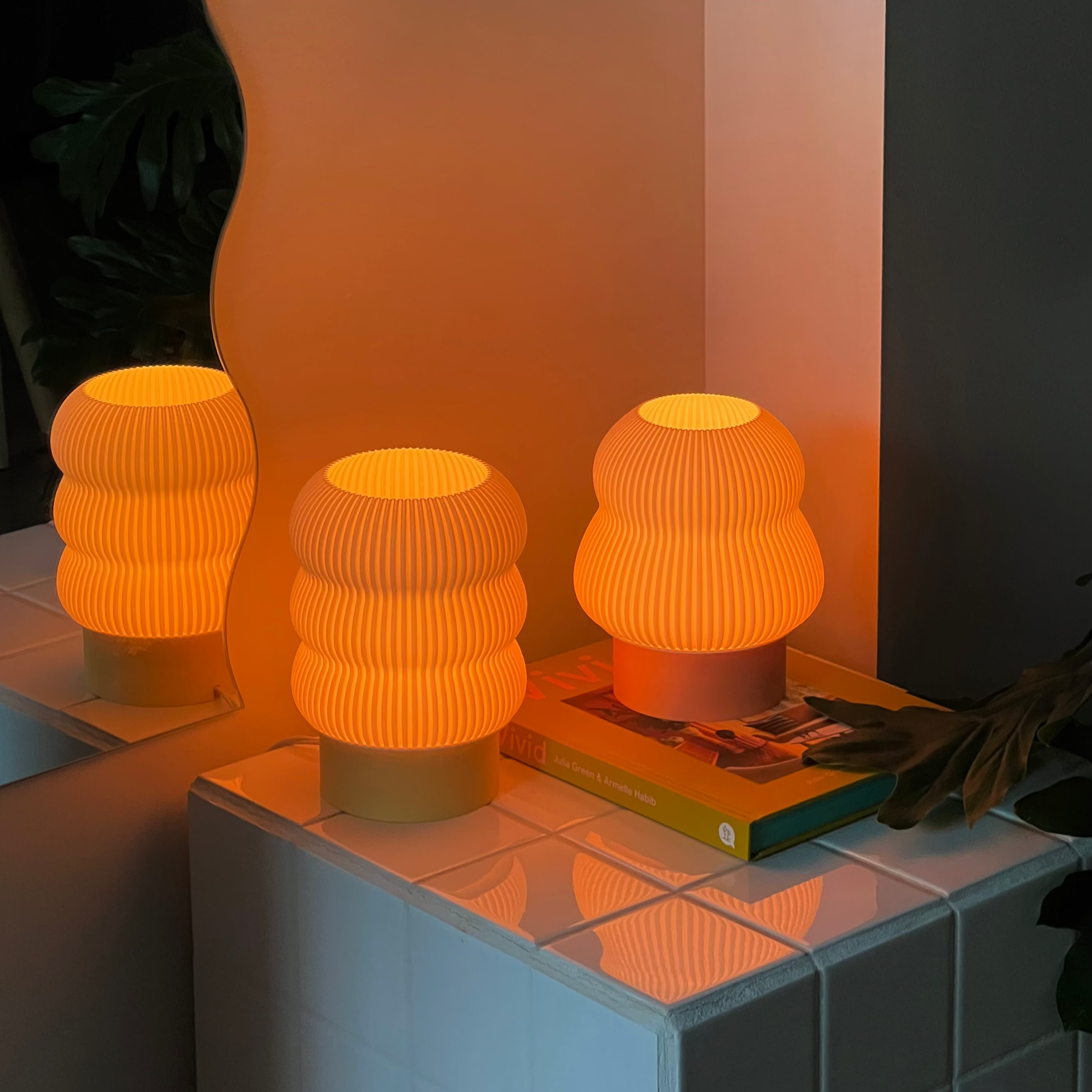 Three orange textured lamps on a tiled surface with a warm glow.