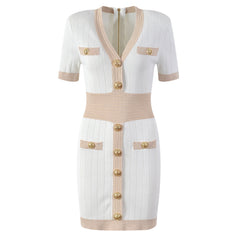 White dress with beige accents and gold buttons on a white background