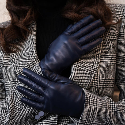 Person wearing dark blue leather gloves with a checkered coat