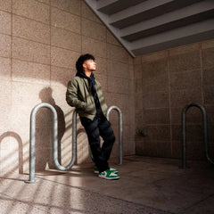 Person leaning against a wall in an urban setting