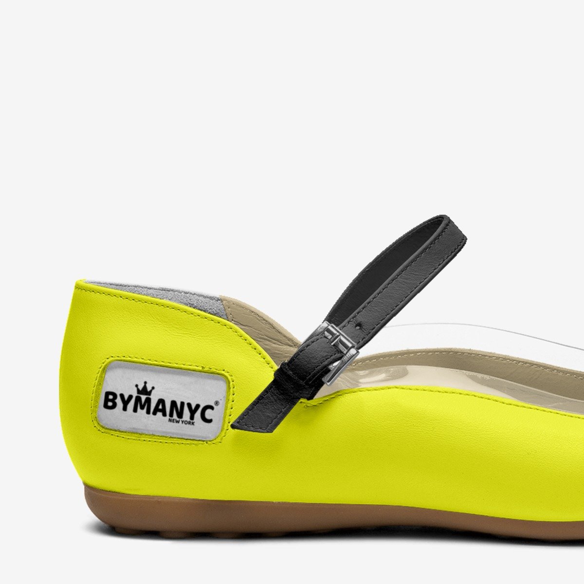 Yellow shoe with a black strap and ByManyc logo on a white background