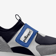 Close-up of a shoe with a blue strap and 'BY MANIC' label on a white background