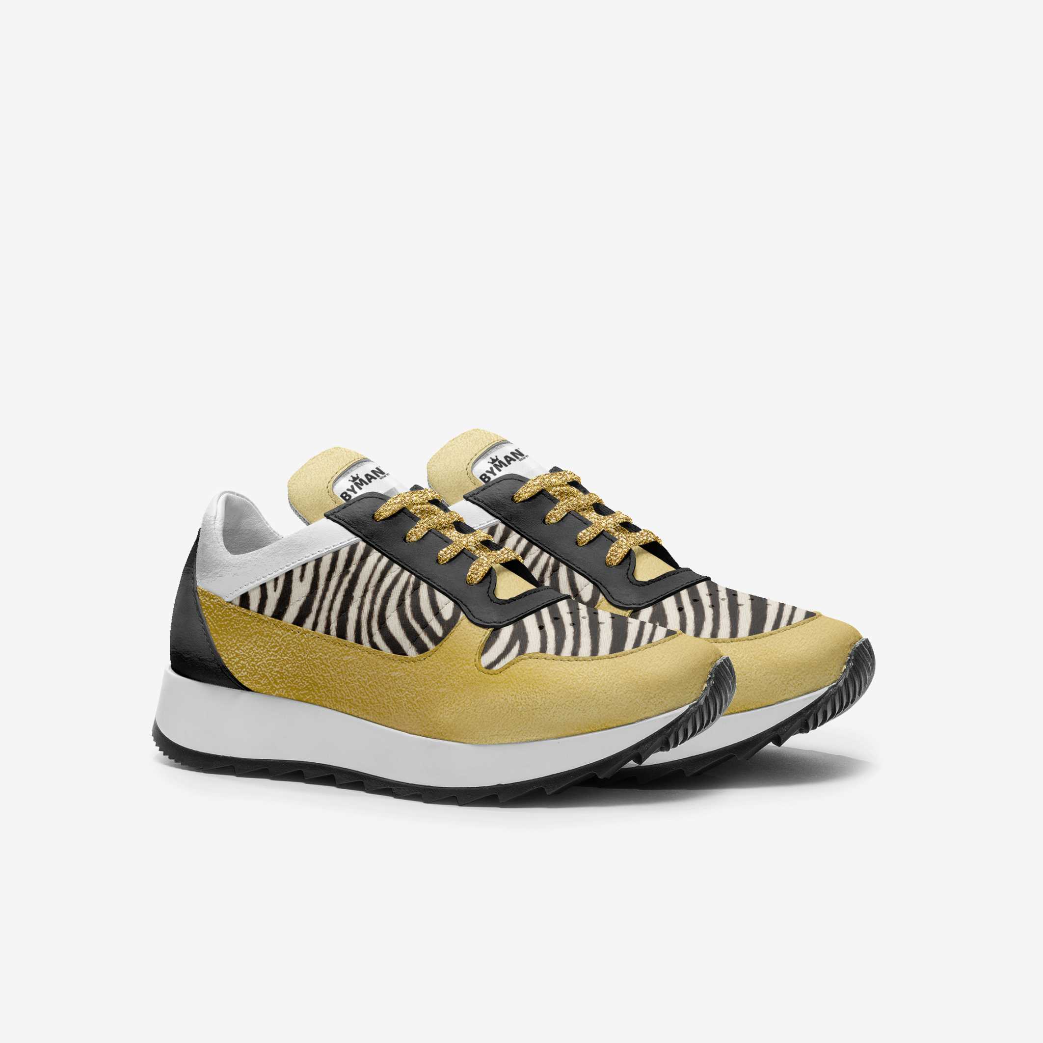 Sneakers with zebra pattern and mustard yellow accents on a white background